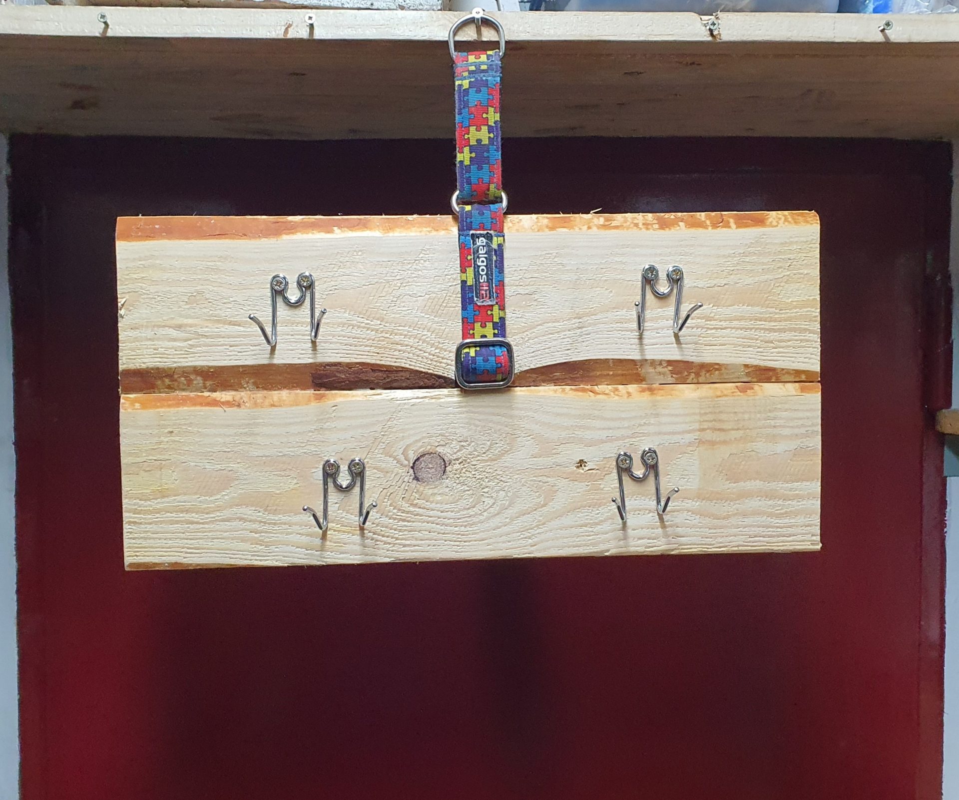 Percha de madera, se cuelga de un collar martingale colocado entre las dos tablas y tiene 4 eslabones de collar de púas para colgar cosas