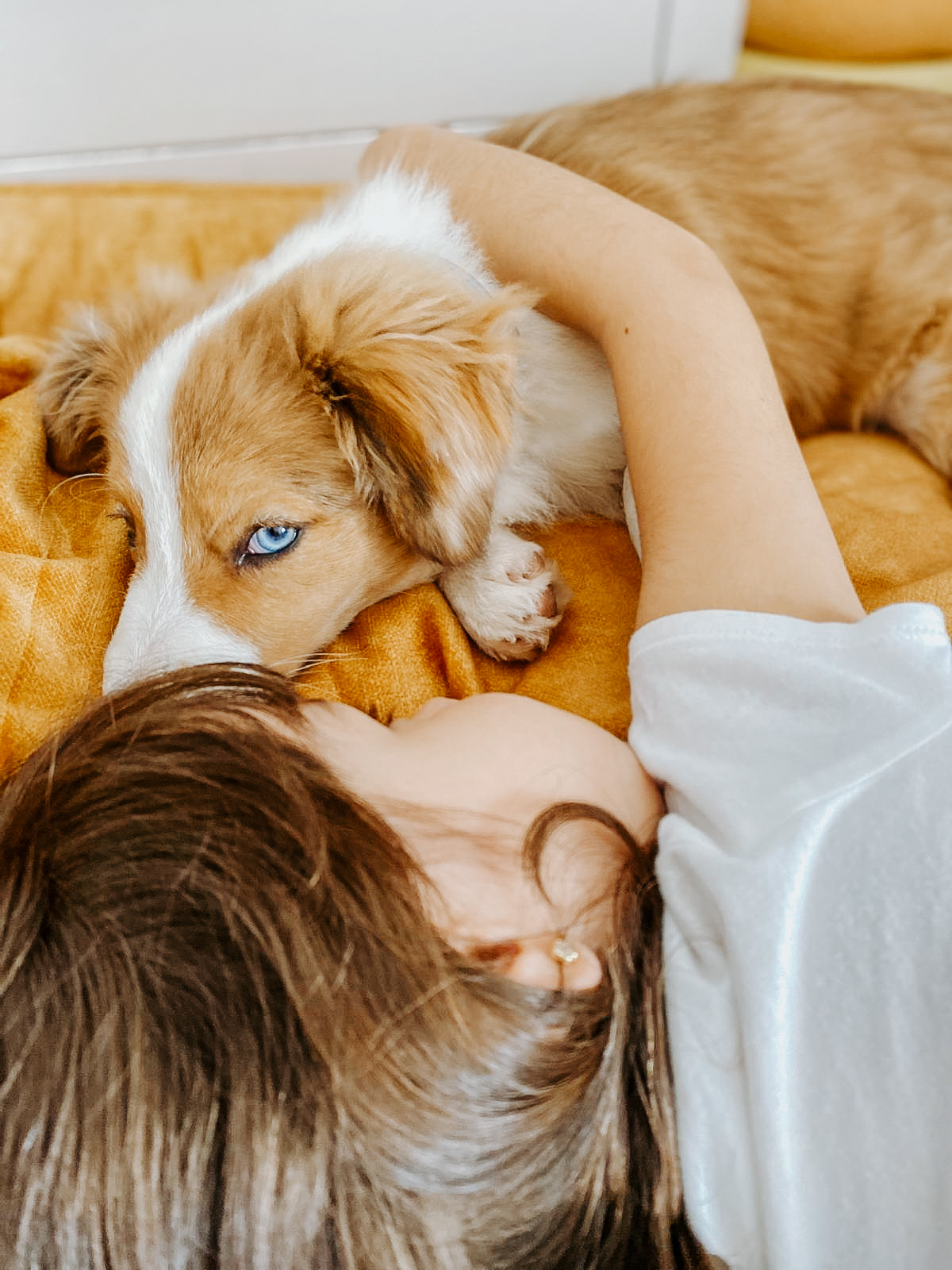 Siena tumbada con su hermana humana pequeña